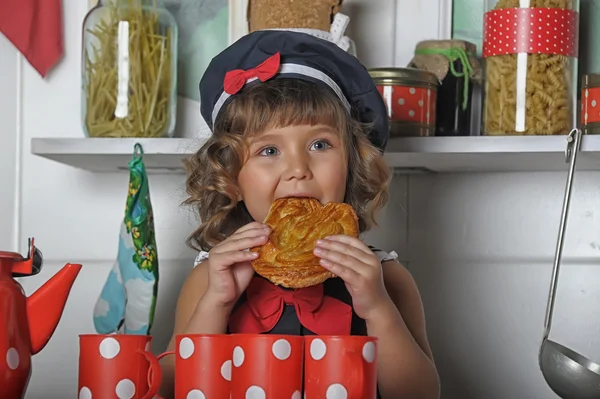 Маленькая девочка в берете и с пирогом в руке — стоковое фото