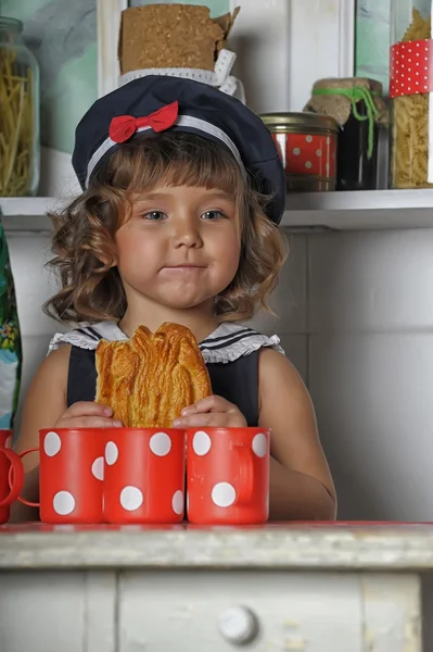 Malá holčička v baret a s koláčem v ruce — Stock fotografie