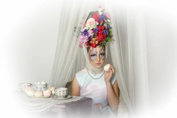 Menina com flores na cabeça durante uma festa de chá — Fotografia de Stock