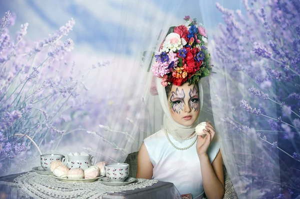 Fille avec des fleurs sur la tête pendant une partie de thé — Photo