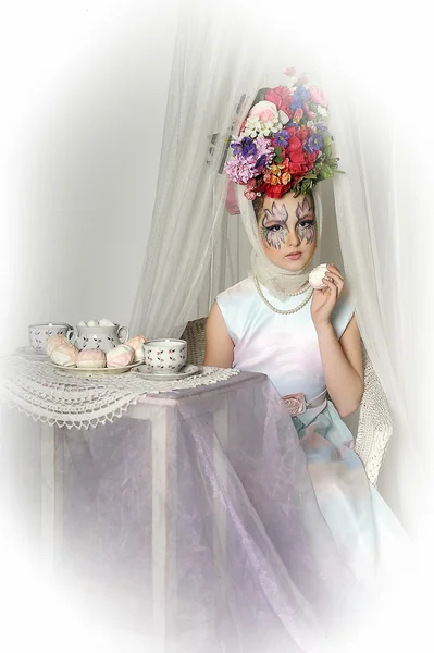 Dívka s květinami na hlavu během čajový dýchánek — Stock fotografie