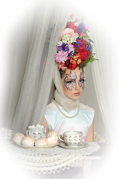 Meisje met bloemen op haar hoofd tijdens een tea party — Stockfoto