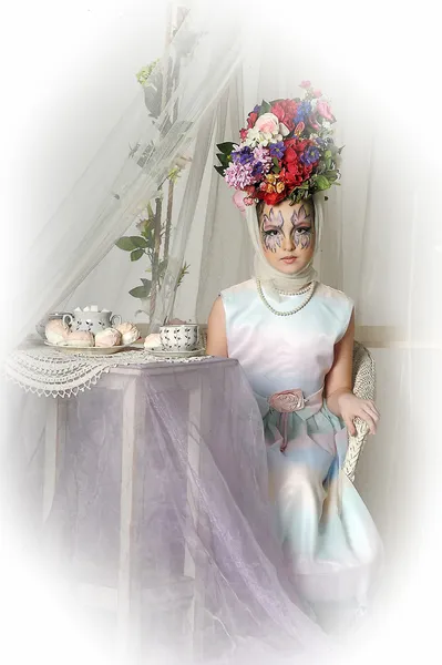 Krásná dívka s květinami na hlavu během čajový dýchánek — Stock fotografie