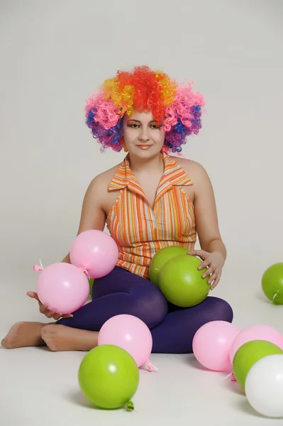 Meisje met ballonnen in een gekleurde pruik — Stockfoto