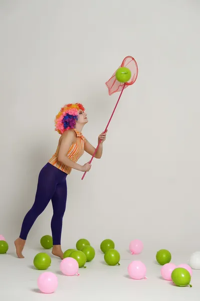 Mädchen mit Luftballons in einer farbigen Perücke — Stockfoto