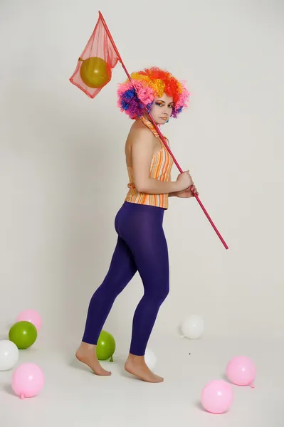 Girl with balloons in a colored wig — Stock Photo, Image