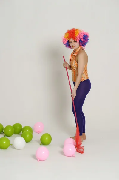 Ragazza con palloncini in una parrucca colorata — Foto Stock