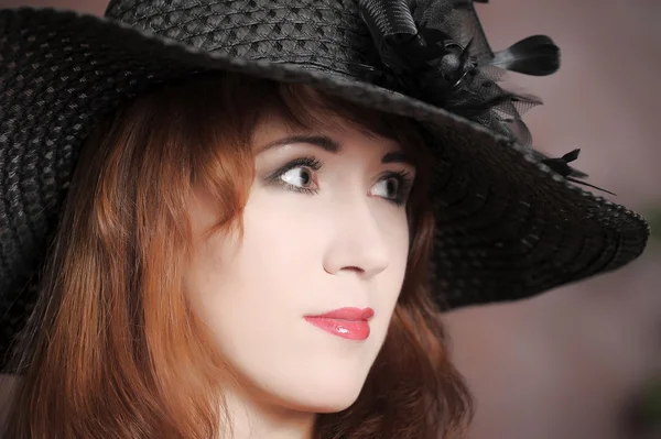 Portrait of a beautiful girl in a black hat — Stock Photo, Image