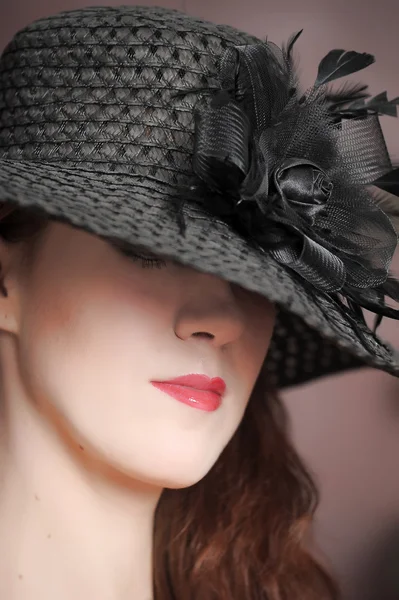 Portrait of a beautiful girl in a black hat — Stock Photo, Image