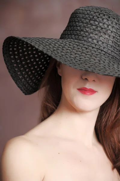 Portrait of a beautiful girl in a black hat — Stock Photo, Image