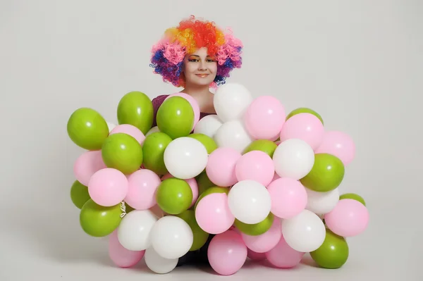 Flicka med ballonger i en färgad peruk — Stockfoto