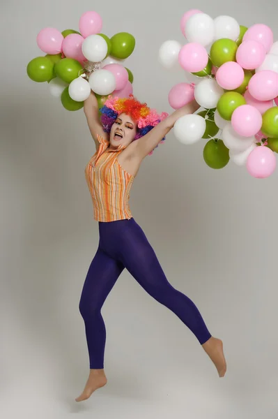 Ragazza con palloncini in una parrucca colorata — Foto Stock