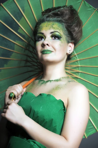 Mulher encantadora segurando um guarda-chuva verde — Fotografia de Stock