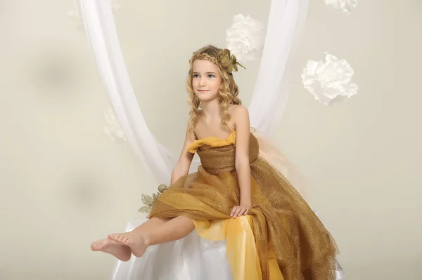 Portret van een mooi meisje in een gouden jurk — Stockfoto