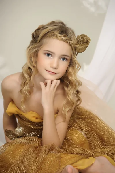 Portrait of a beautiful girl in a gold dress — Stock Photo, Image