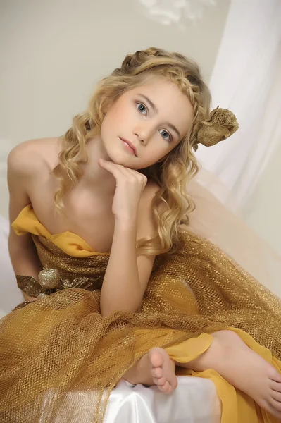 Portrait of a beautiful girl in a gold dress — Stock Photo, Image