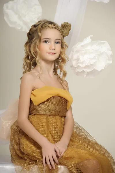 Πορτρέτο του ένα όμορφο κορίτσι σε ένα χρυσό φόρεμα — Φωτογραφία Αρχείου