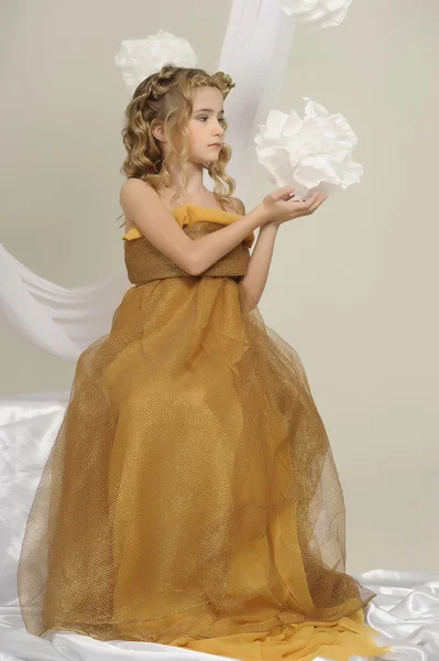 Retrato de uma menina bonita em um vestido de ouro — Fotografia de Stock