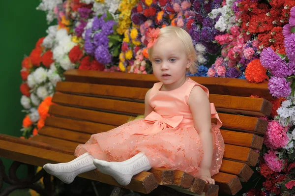 Bambino vicino alle panche con fiori sullo sfondo — Foto Stock