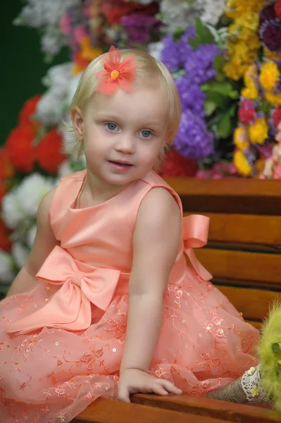 Kind in der Nähe der Bänke mit Blumen im Hintergrund — Stockfoto