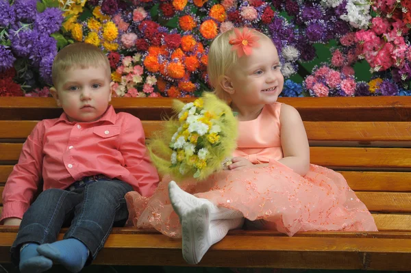 Dítě u lavičky s květinami na pozadí — Stock fotografie