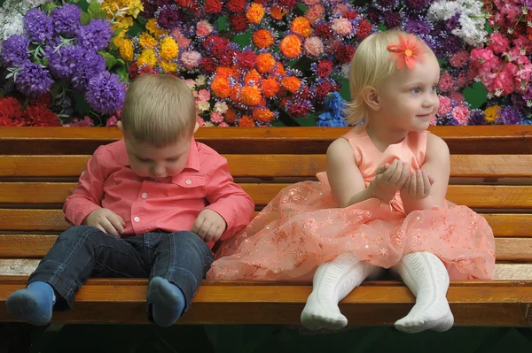 Dítě u lavičky s květinami na pozadí — Stock fotografie