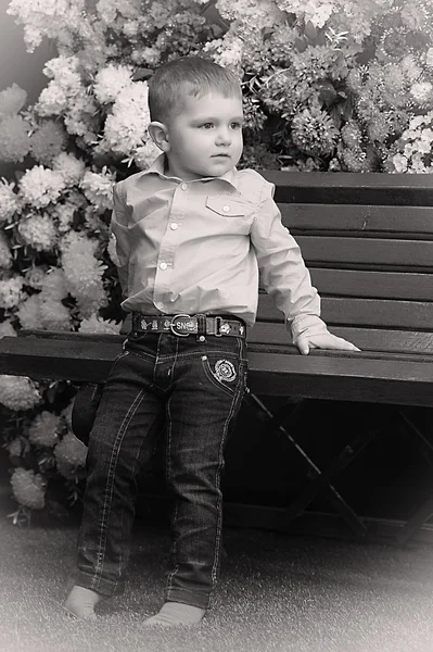 Pequeño niño en un banco — Foto de Stock