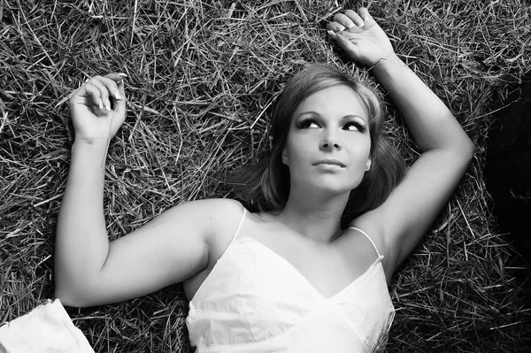 美しい若い女性は、飼い葉おけに横たわる — ストック写真