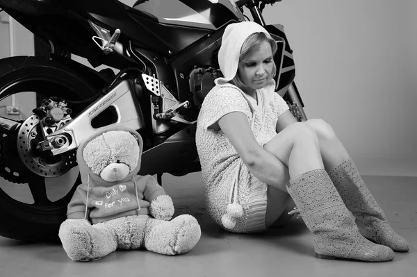 Zamyšlená dívka v růžovém s medvídek na pozadí motocyklu — Stock fotografie