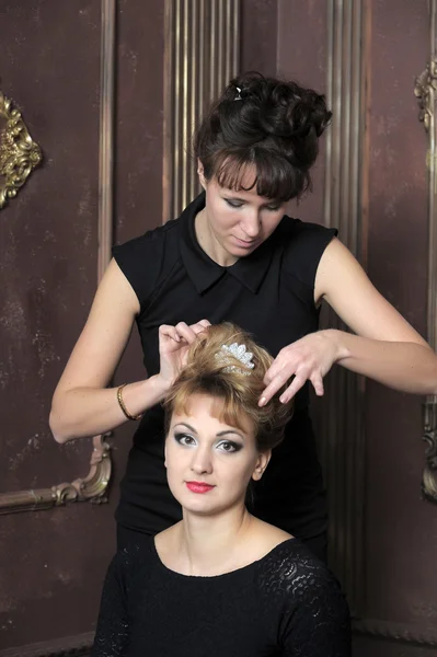 Hairdresser makes hairstyle for young pretty women — Stock Photo, Image