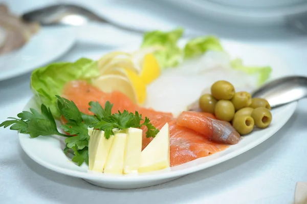 Salmon with cheese, olives and parsley on the plate — Stock Photo, Image