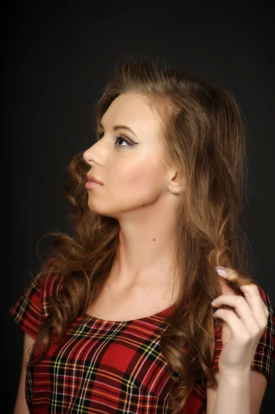 Beautiful girl in a checkered dress — Stock Photo, Image