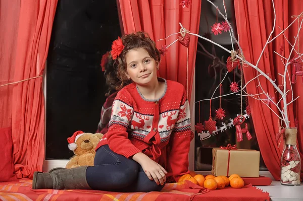Karácsonyi portré egy fiatal lány, egy vörös pulóverben — Stock Fotó