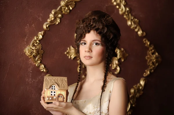 Porträtt av en vacker kvinna med lilla huset i händer — Stockfoto