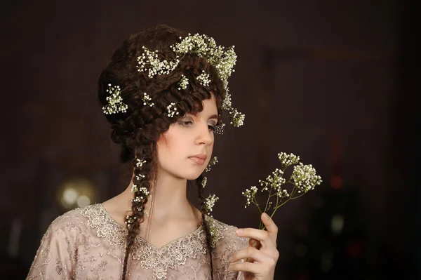 Retrato de uma bela jovem com flores no cabelo — Fotografia de Stock