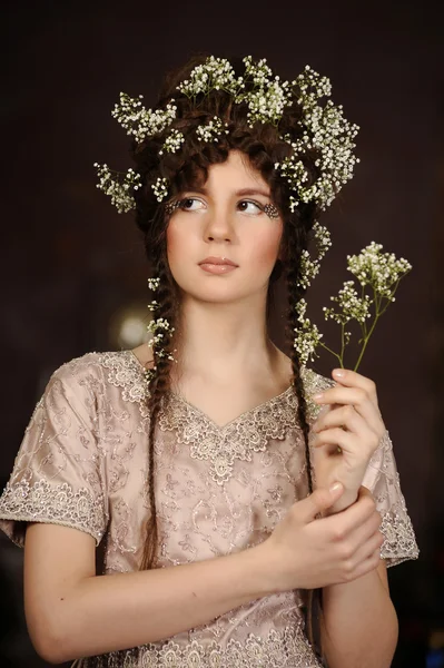 Porträtt av en vacker ung kvinna med blommor i håret — Stockfoto