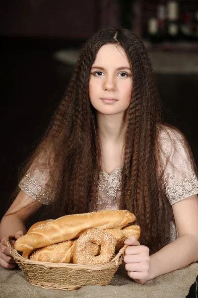 Vacker flicka med bröd produkter i korg — Stockfoto