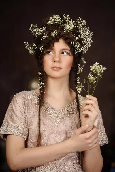 Portret van een mooie jonge vrouw met bloemen in haar haar Stockafbeelding