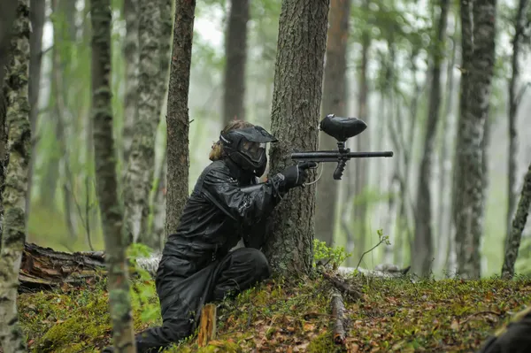 Paintball player aiming in the forest — Stock Photo, Image