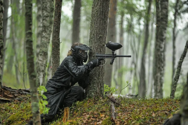Paintball player aiming in the forest — Stock Photo, Image