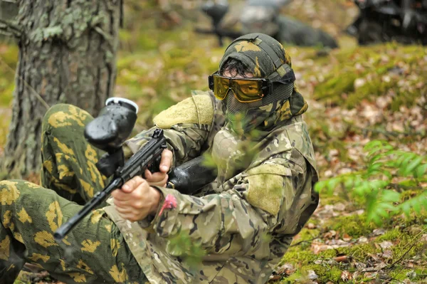 Jogador de Paintball apontando na floresta — Fotografia de Stock