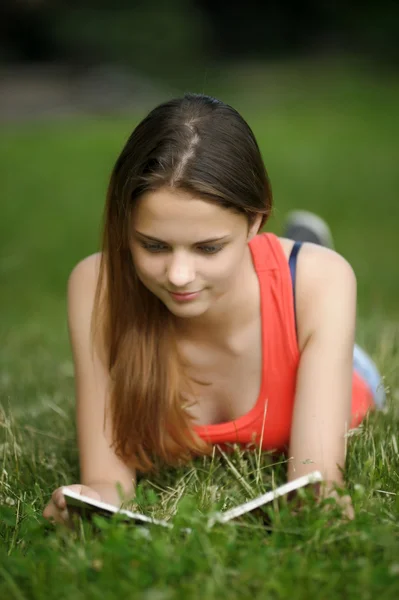 La muchacha sobre la hierba con el libro — Foto de Stock