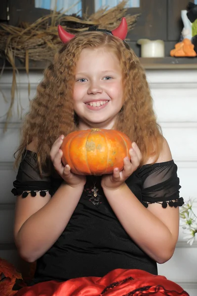 Evil red-haired girl with pumpkin — Stock Photo, Image