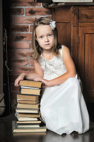 Menina com uma grande pilha de livros, foto em estilo vintage — Fotografia de Stock