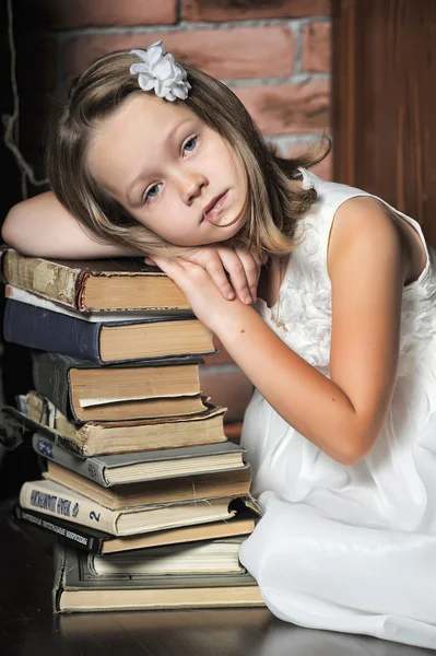 Menina com uma grande pilha de livros, foto em estilo vintage — Fotografia de Stock