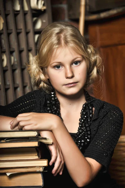 Schoolgirl girl in retro library — Stock Photo, Image