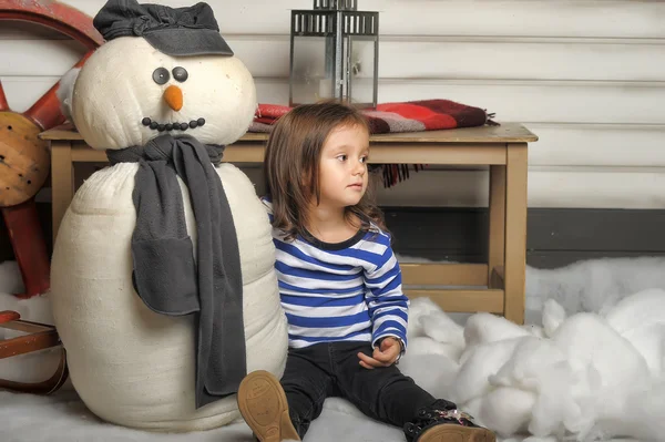 Ragazza con un pupazzo di neve giocattolo — Foto Stock