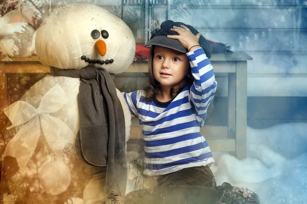 Flicka med en leksak snögubbe — Stockfoto