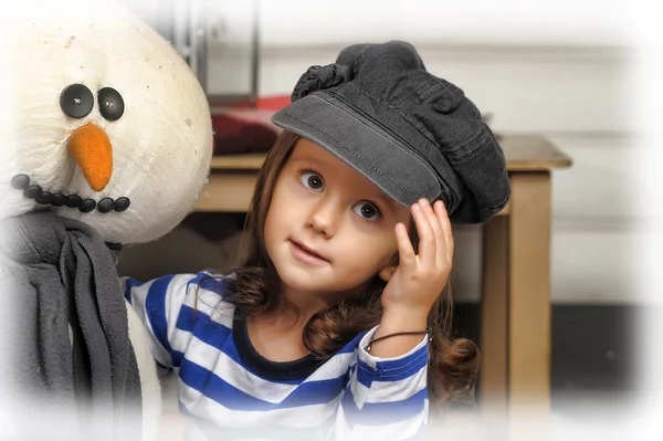 Girl with a toy snowman — Stock Photo, Image