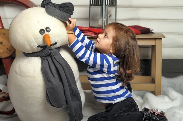 Menina com um boneco de neve de brinquedo — Fotografia de Stock